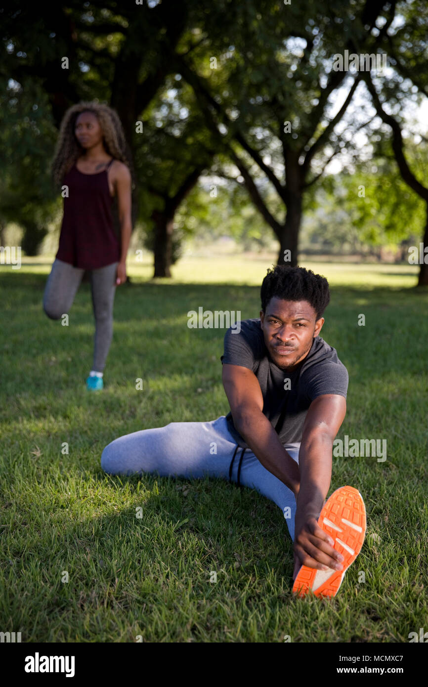 Man and woman stretching in a park Stock Photo