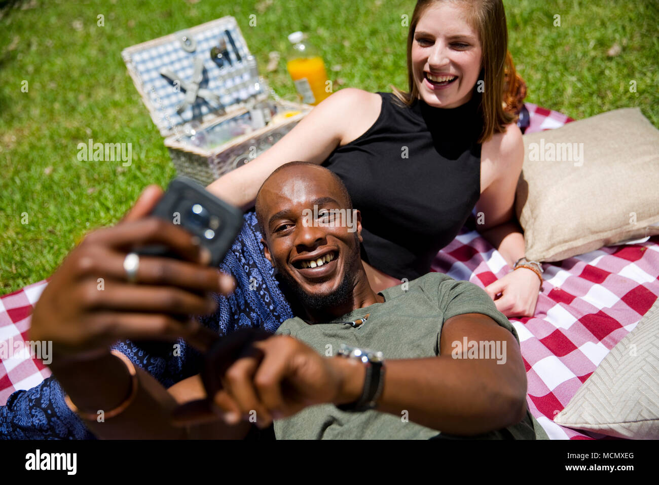 Couple taking a selfie at a picnic in a park Stock Photo