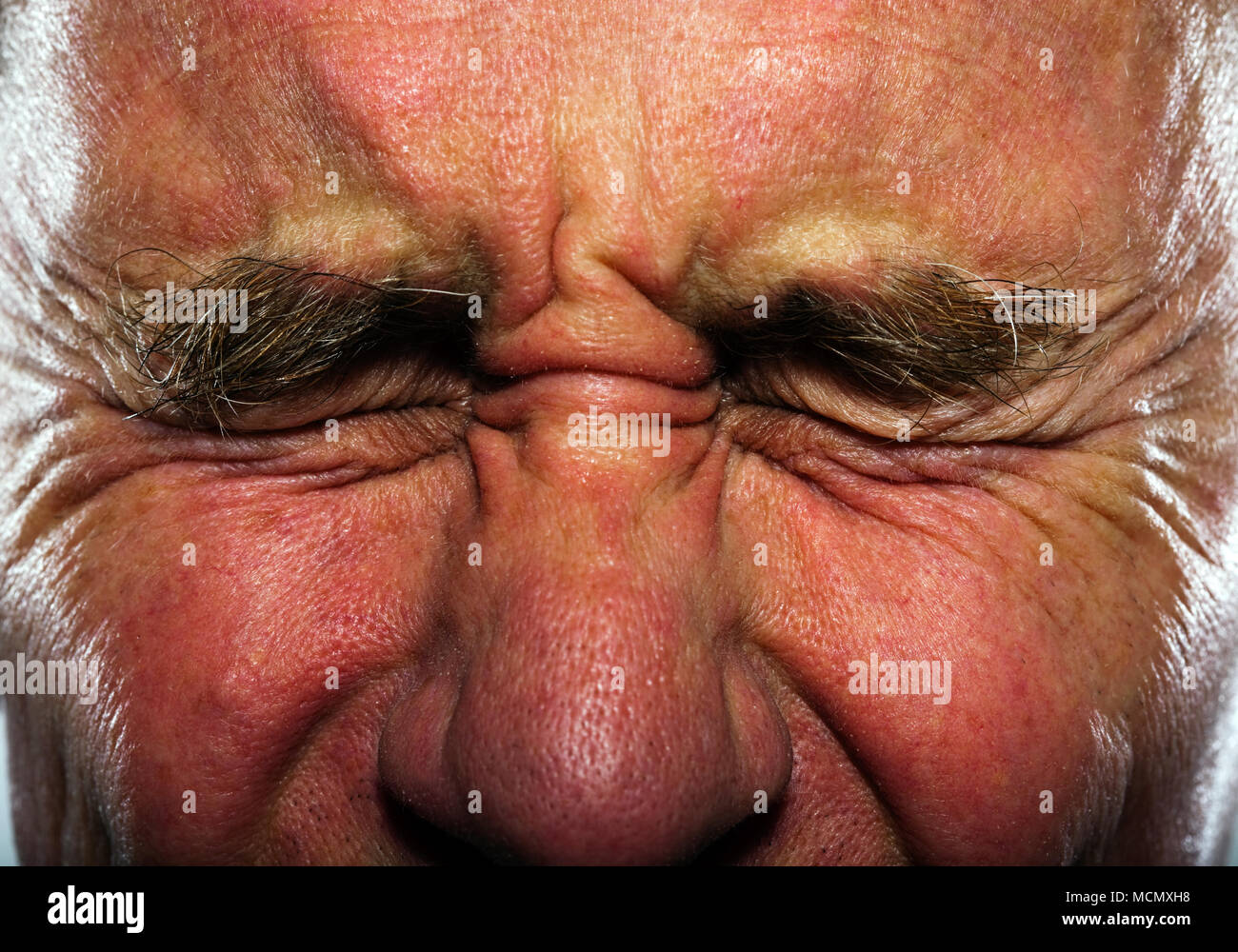 Middle aged man with eyes tightly closed Stock Photo