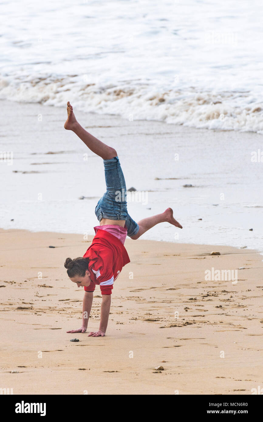 A young girl performing a handstand on Fistral Beach in Newquay Cornwall. Stock Photo