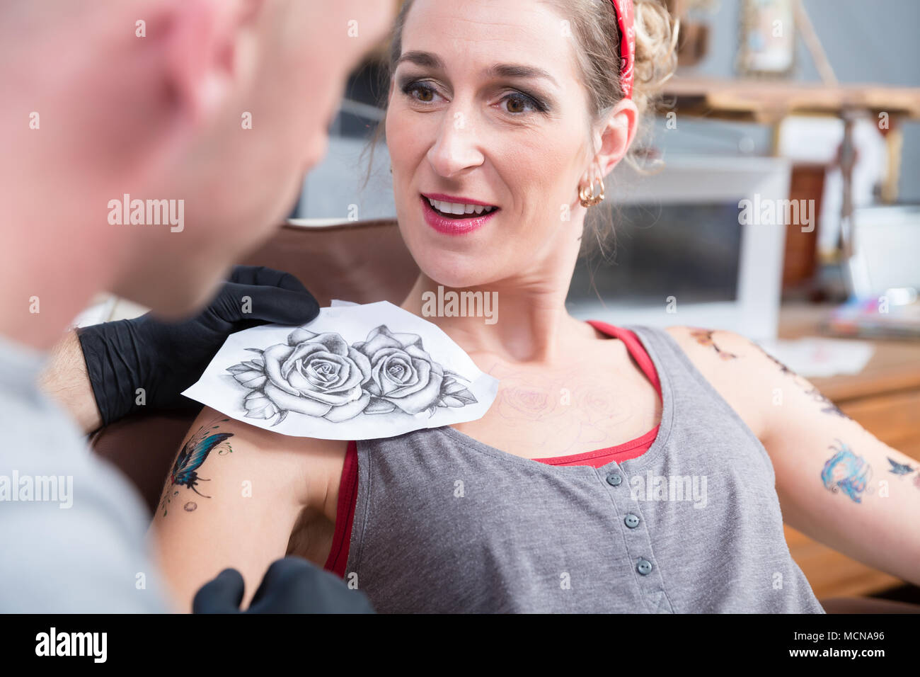 Portrait of a woman getting a new tattoo in a professional studio Stock Photo