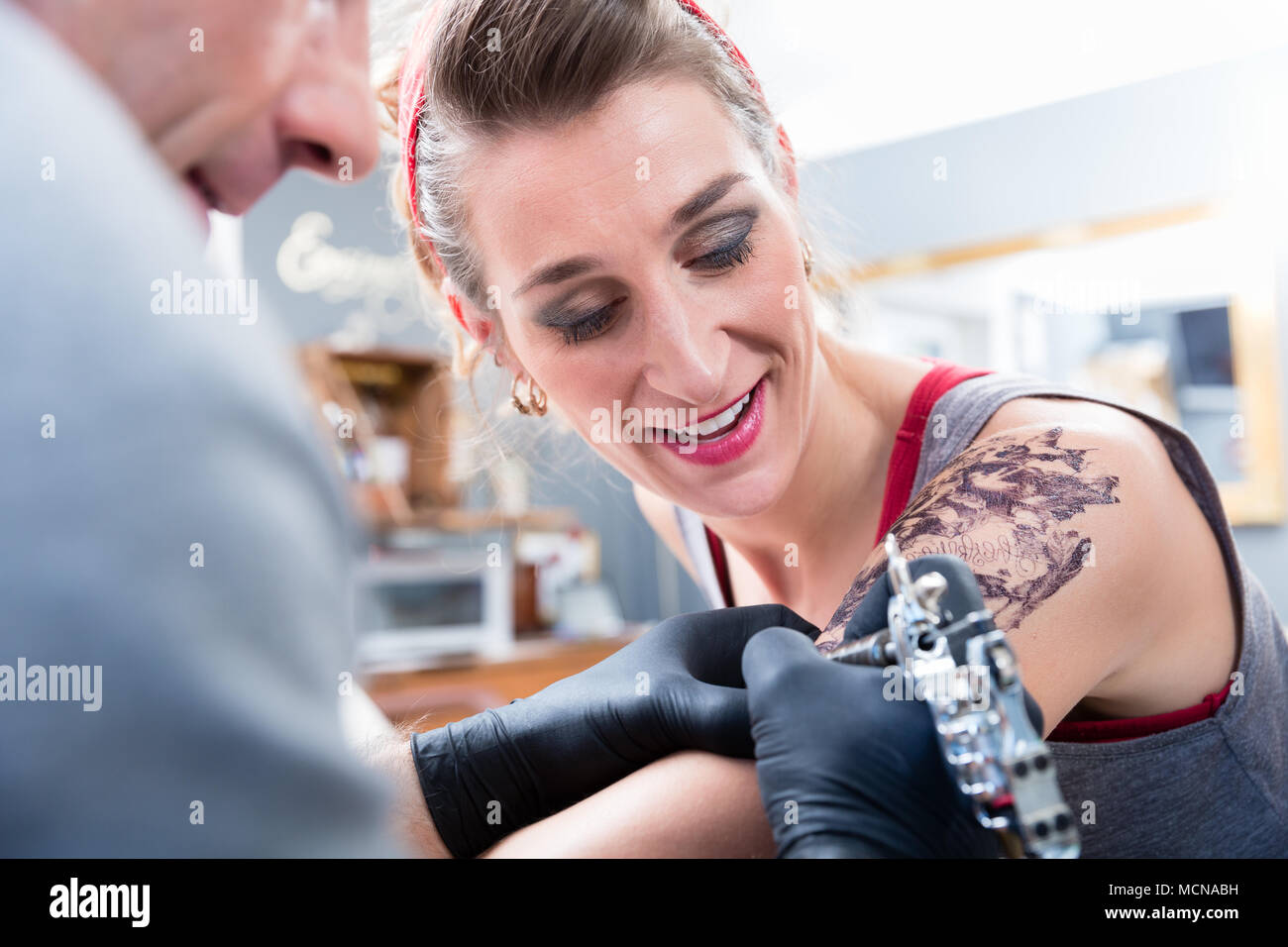 Cheerful woman smiling with confidence in a modern tattoo studio Stock Photo