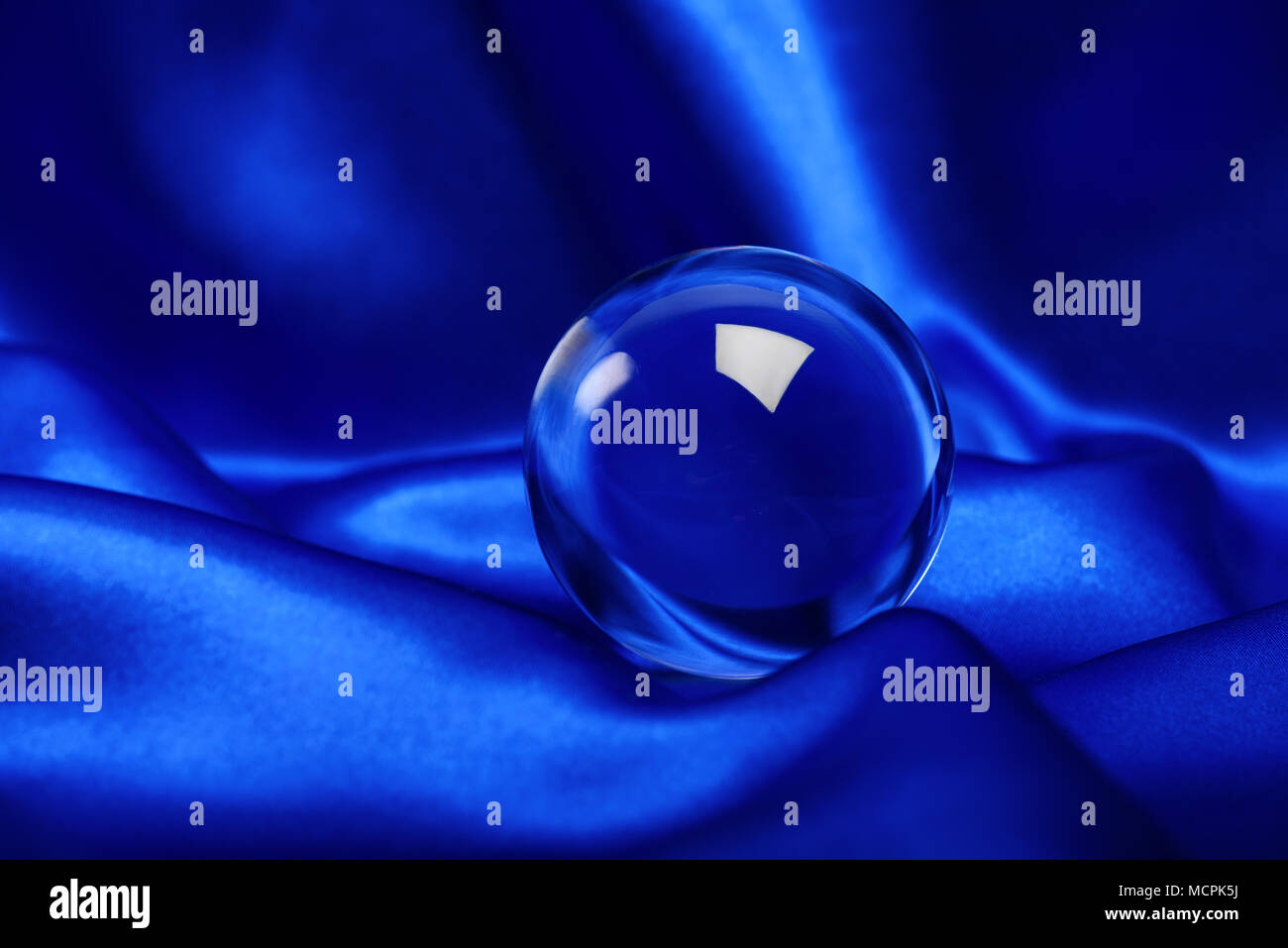 glowing crystal ball shot on blue canvas Stock Photo