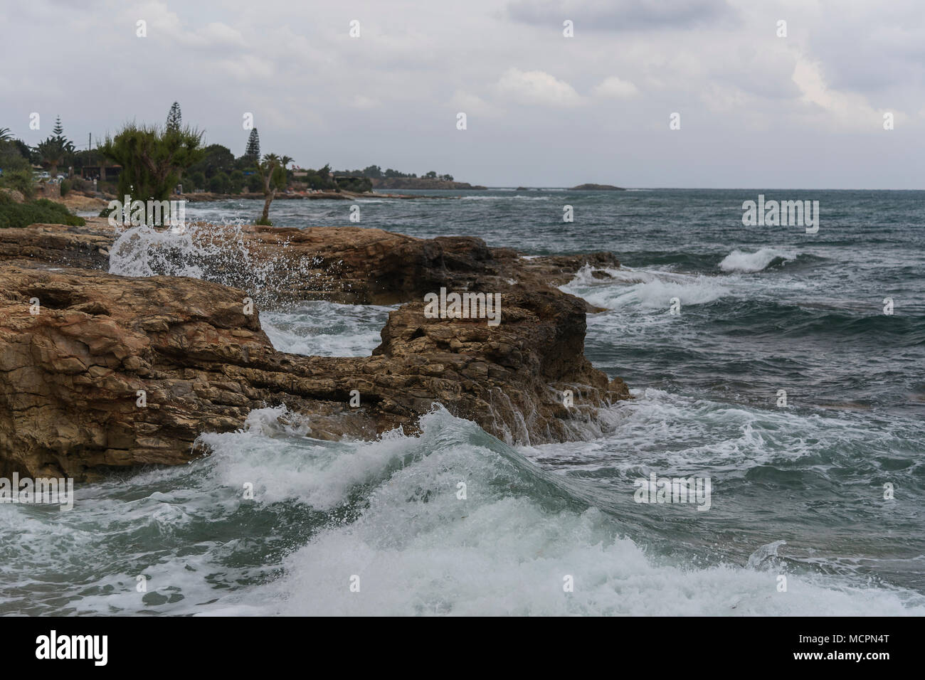 Die Brandung bricht sich an den Felsen an der Küste von Chersonissos Stock Photo