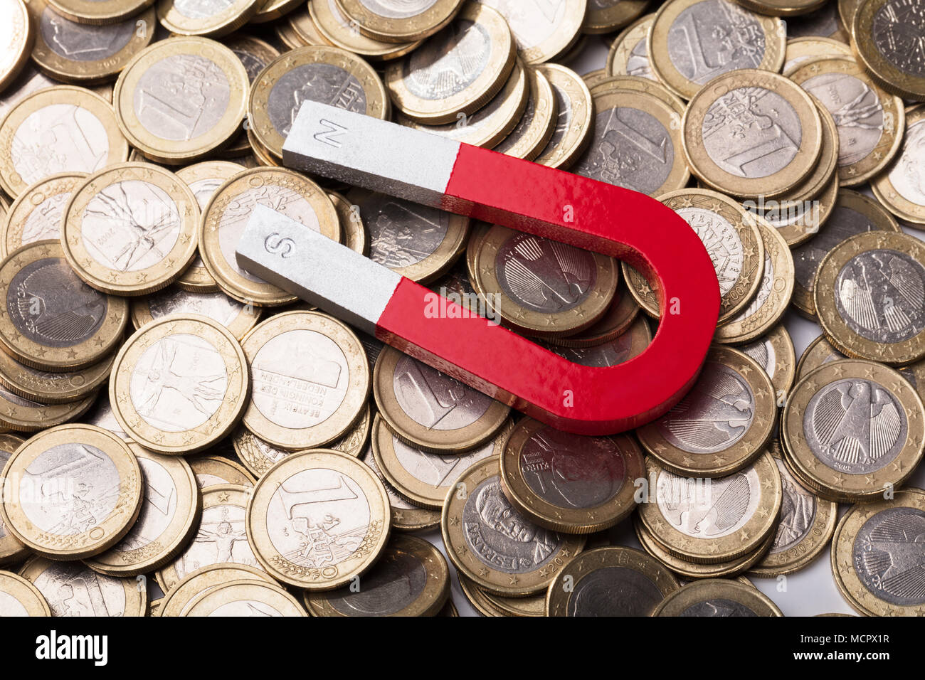 Elevated View Of A Red Horseshoe Magnet On Euro Coins Stock Photo
