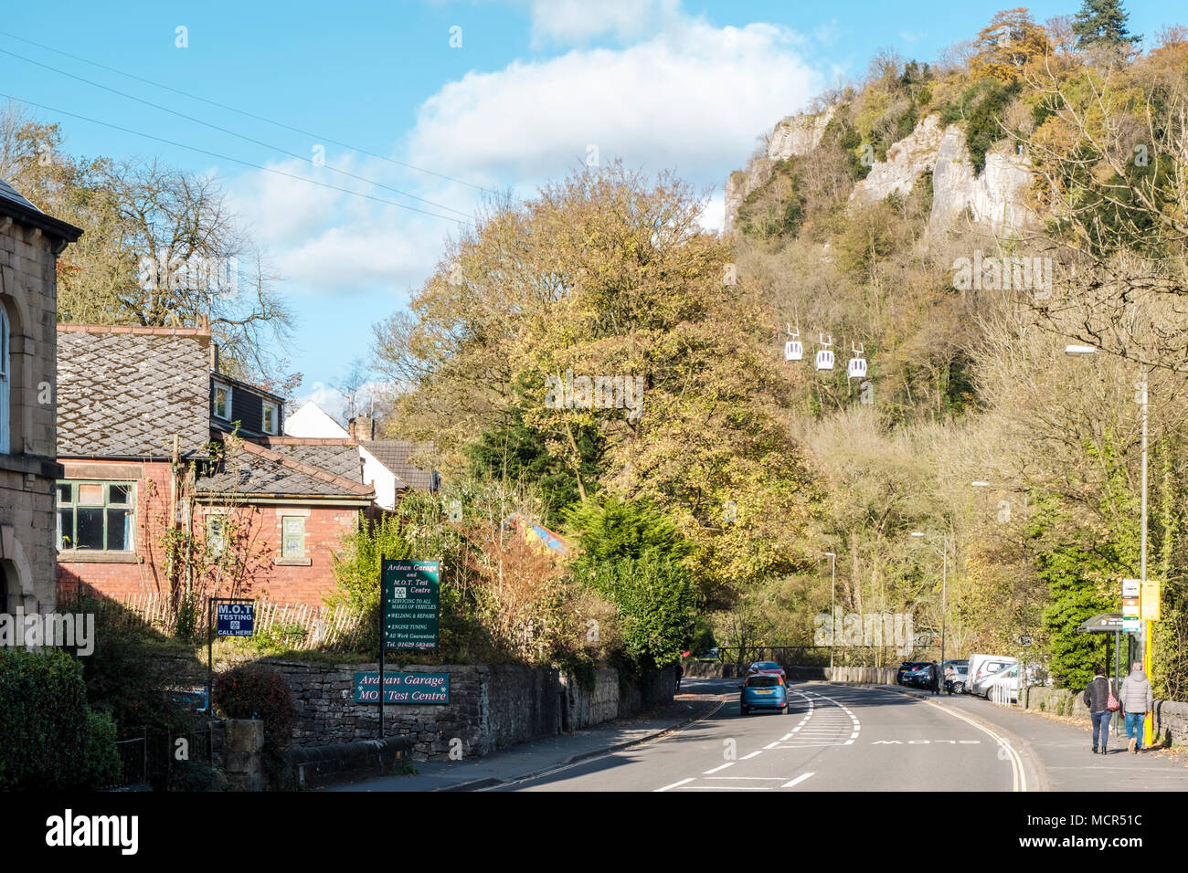 A6 road in Matlock Bath during Autumn with High Tor on the right and cable cars travelling past. Derbyshire, England, UK Stock Photo