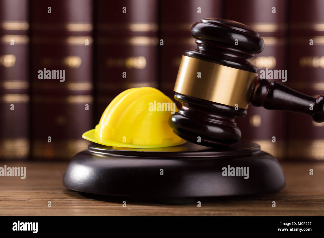 Close-up Of Gavel And Yellow Hard Hat In Courtroom Stock Photo