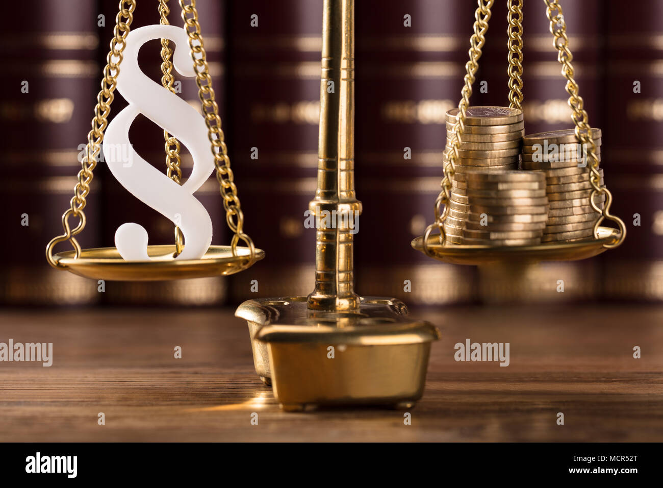 Close-up Of White Paragraph Symbol And Stacked Golden Coins On Justice Scale Stock Photo