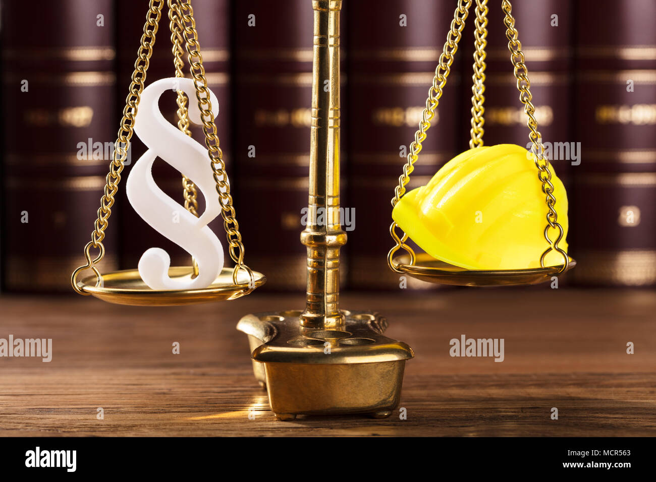 Close-up Of White Paragraph Symbol And Yellow Hard Hat On Justice Scale Stock Photo
