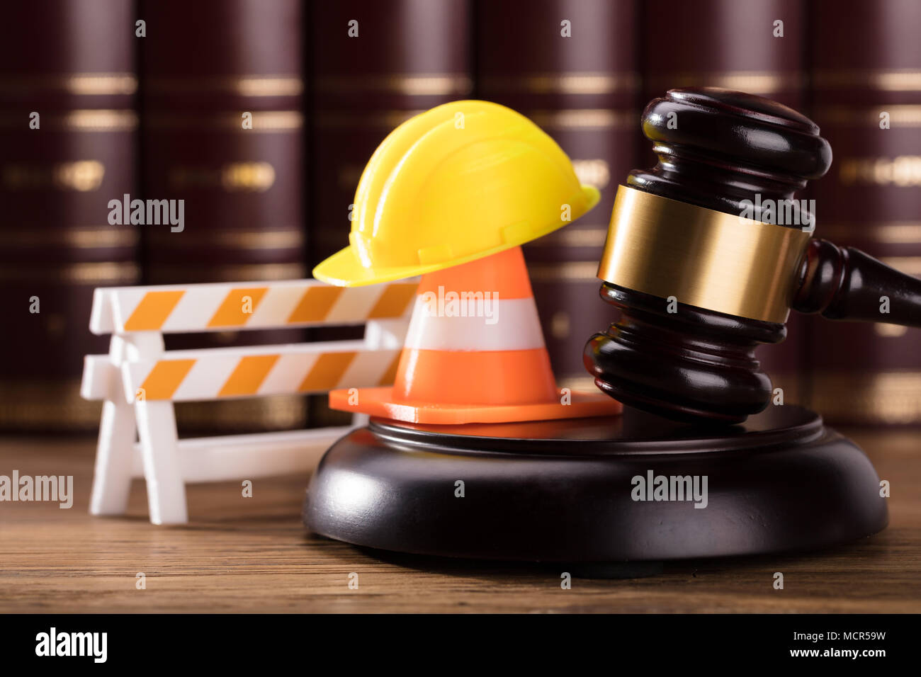 Close-up Of Mallet With Road Barrier, Yellow Hard Hat And Traffic Cone In Courtroom Stock Photo