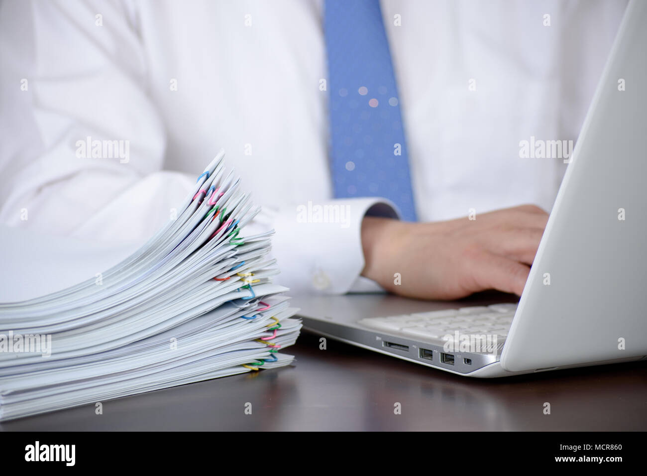 A businessman organizing a large number of documents. Stock Photo