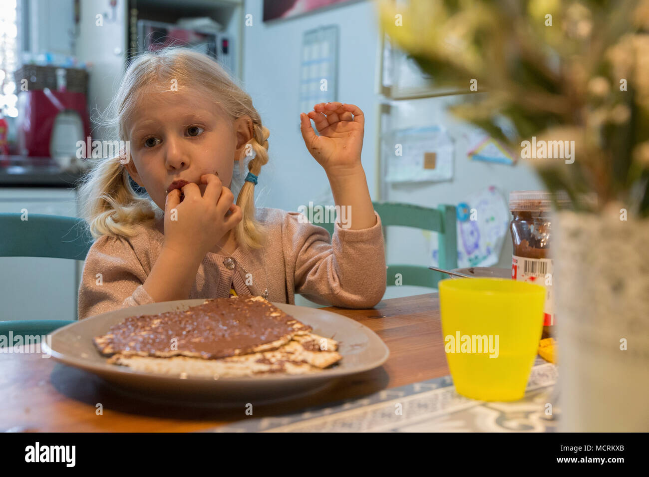 Portrait of a young girl of five eats Matzo with chocolate spread during Passover Model release available Stock Photo