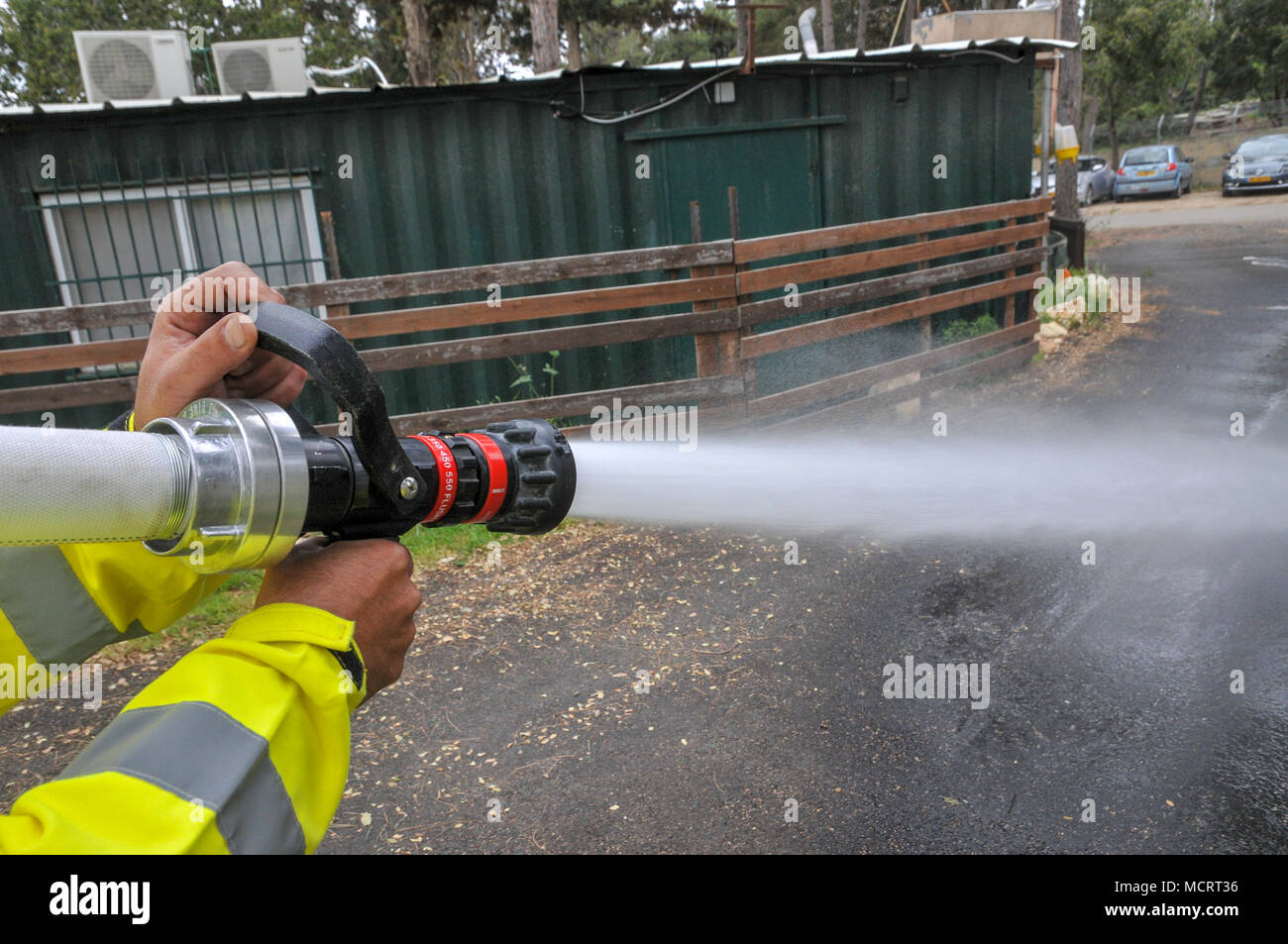 Fireman in protective clothing extinguishes a fire as part of a fire fighting drill Stock Photo