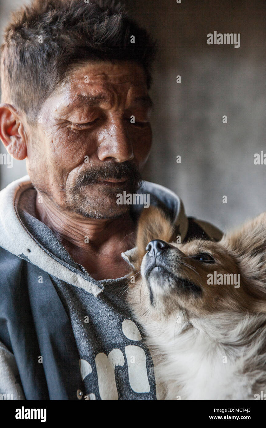 Portrait of man and pet dog looking at each other, Patan, Bagmati, Nepal Stock Photo