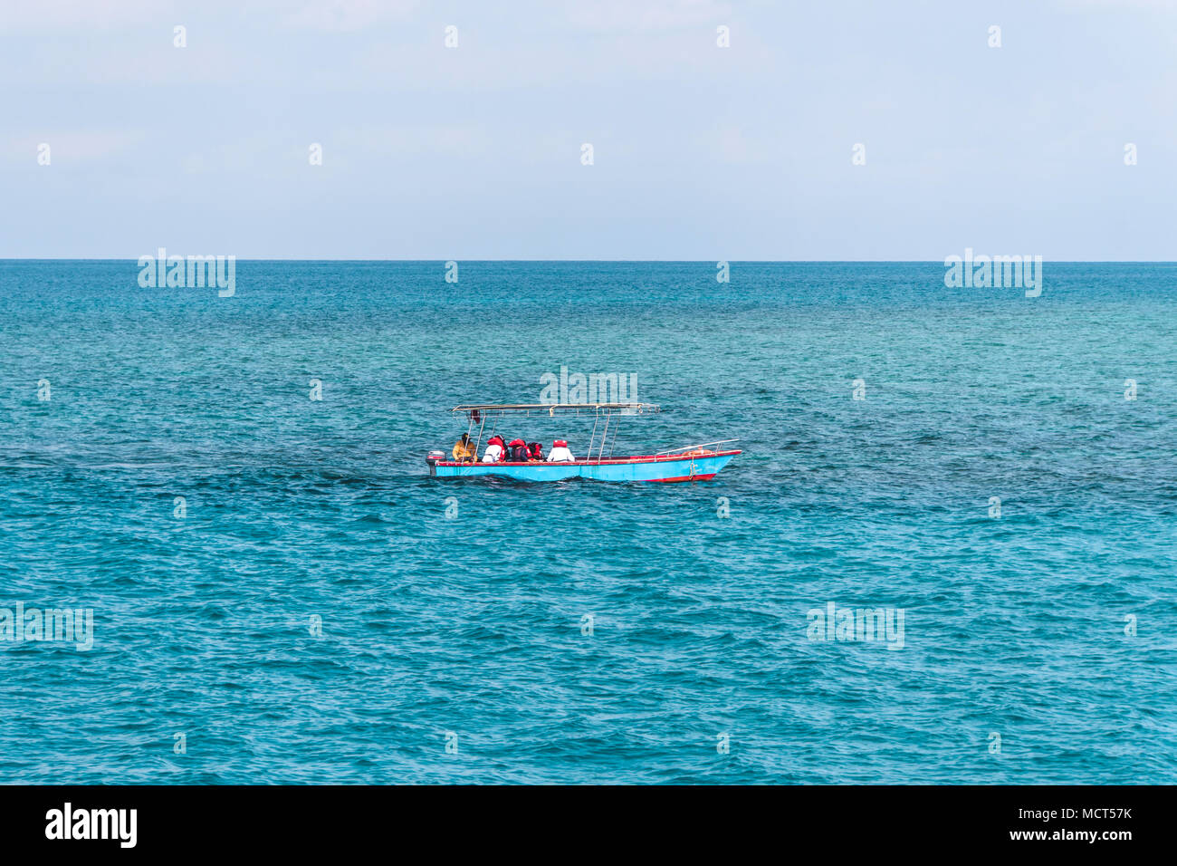 A small boat floats on the sea. Beautiful sea landscape. Fishermen are going in the sea for fishing in small boat. Stock Photo