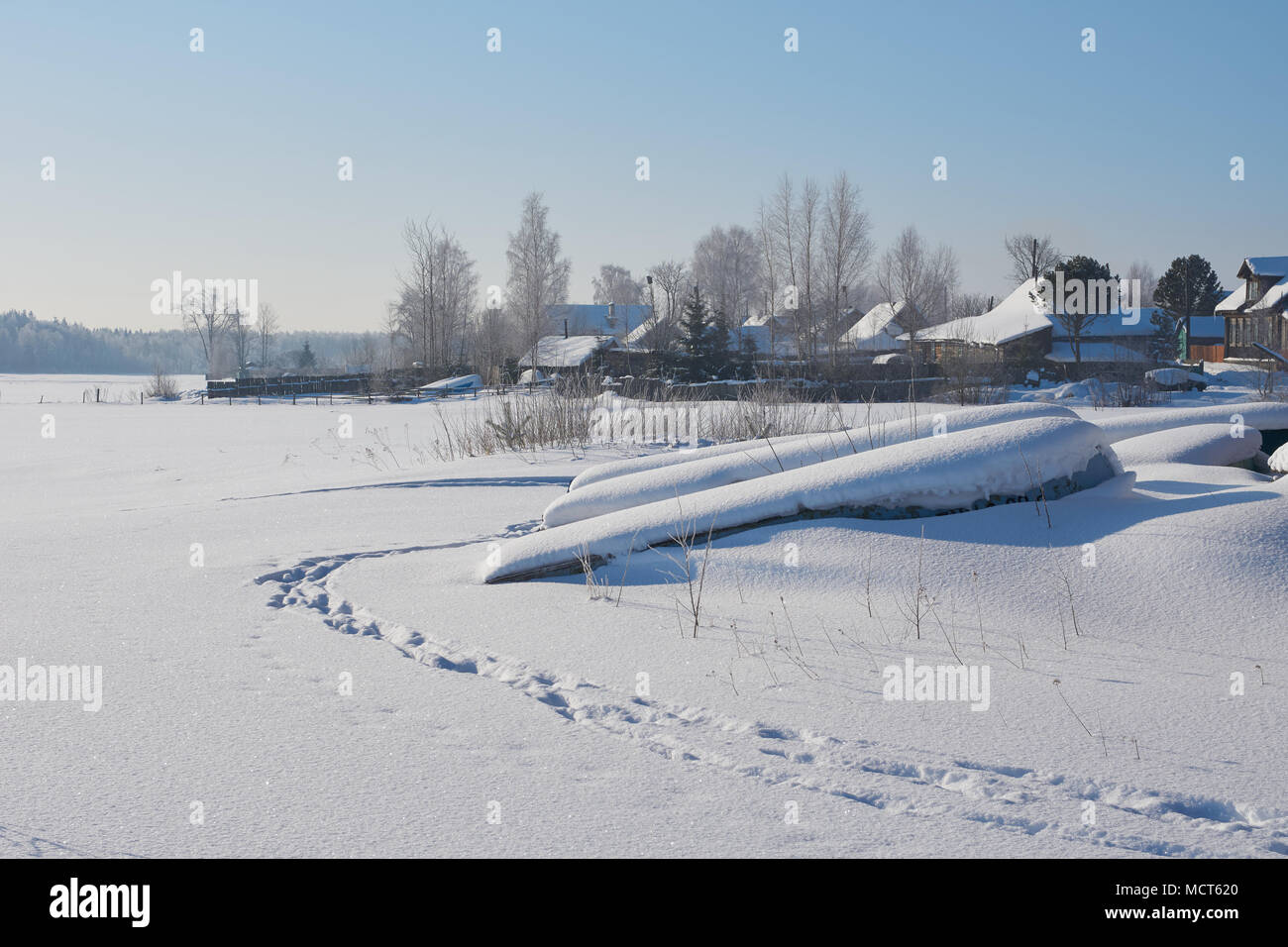 Sunny winter landscape with flipped over boats on Peno lake. Peno town, Tver oblast, Russia. Stock Photo