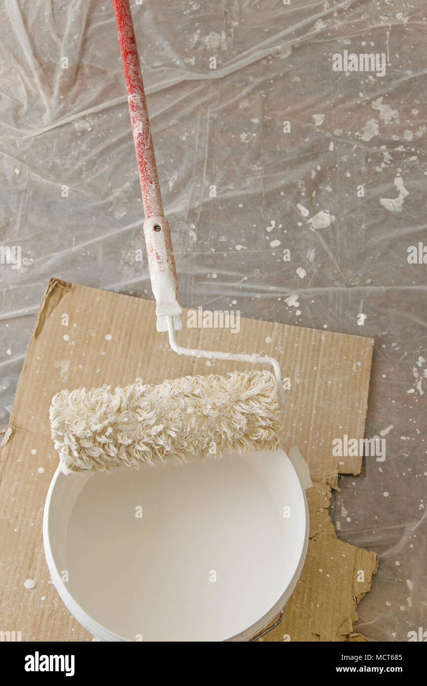 Top View Of Roller Cover With Paint From A Bucket The Floor Is