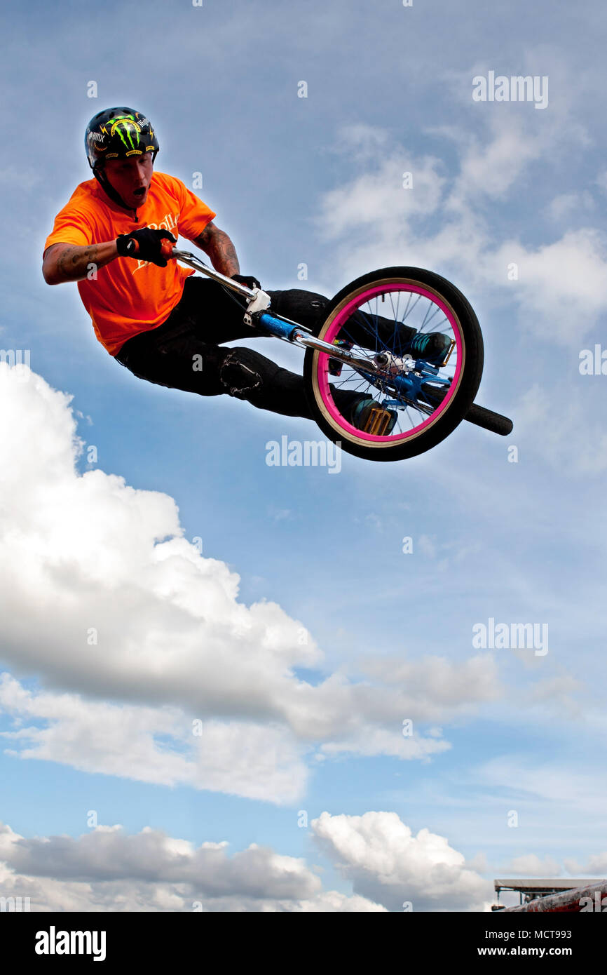 A young man with the High Roller BMX club rotates his bike in midair doing a BMX stunt at the Georgia State Fair on September 27, 2014 in Hampton, GA. Stock Photo