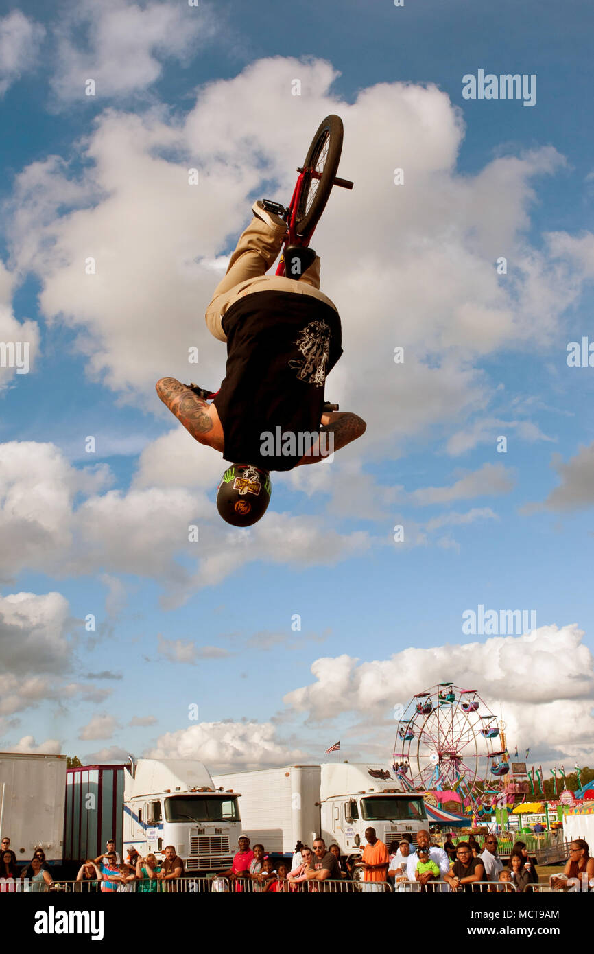 A young man with the High Roller BMX club flips upside down doing a BMX stunt at the Georgia State Fair on September 27, 2014 in Hampton, GA. Stock Photo