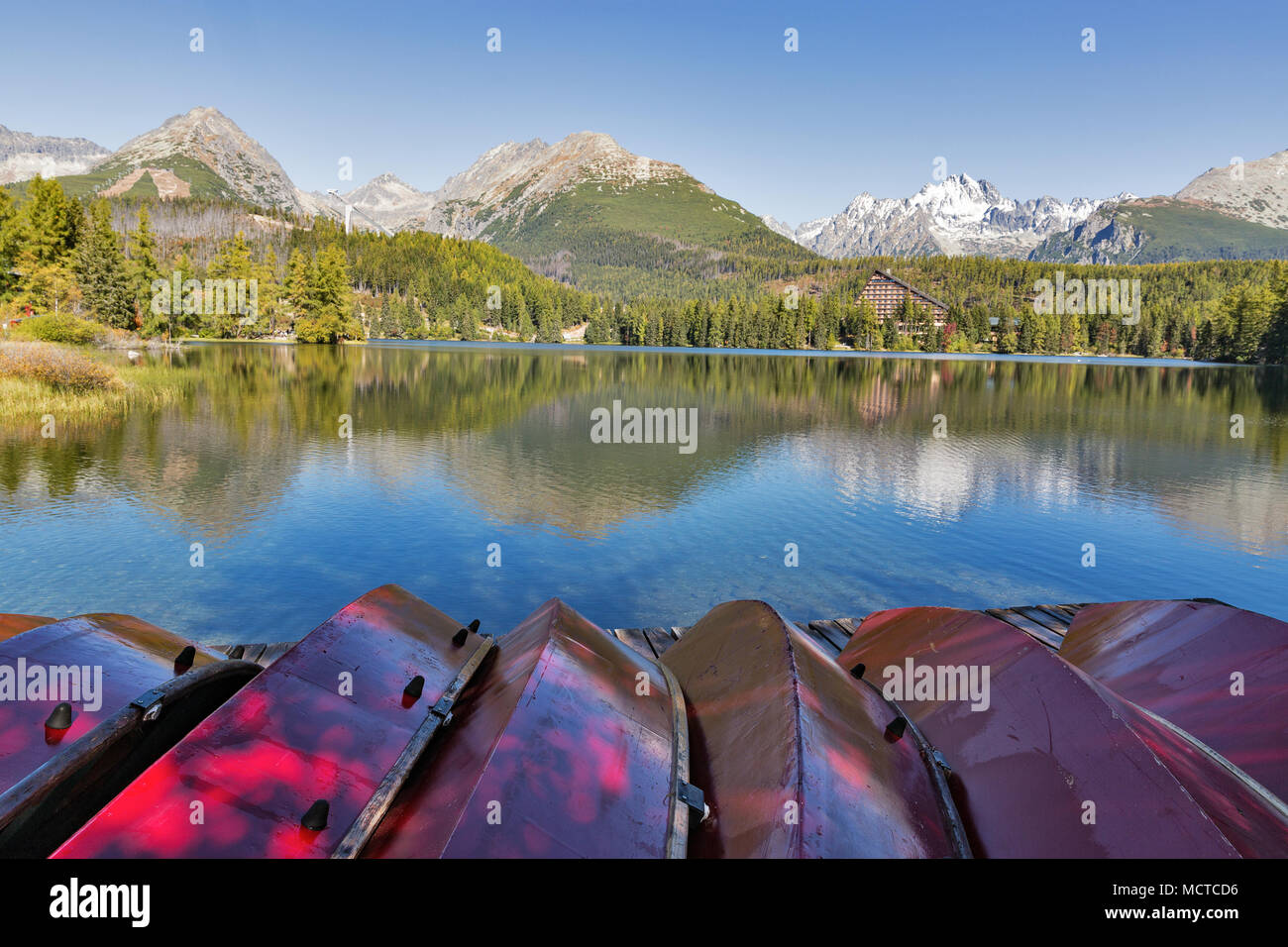 Red flipped over recreational boats on Strbske Lake shore in Slovakia. It is a favorite ski, tourist, and health resort in the High Tatras. Stock Photo