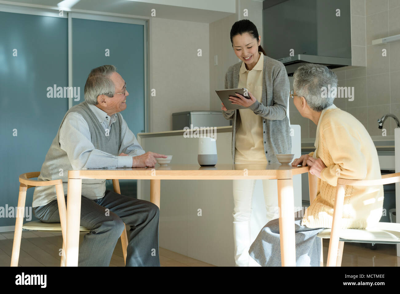 Care worker asking about senior couple's condition Stock Photo