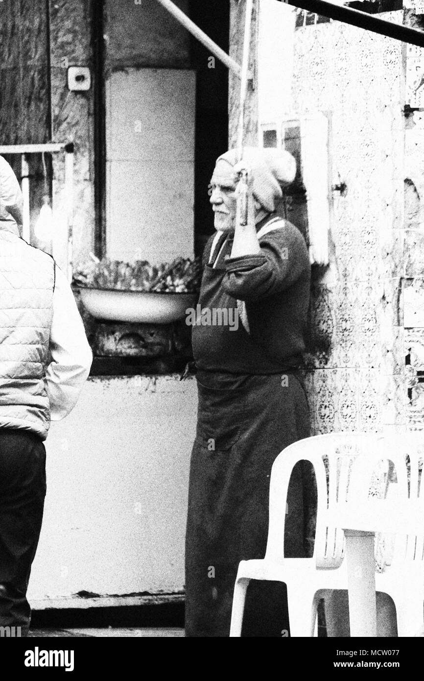 Old fashioned black and white picture of grumpy salesman or chef in front of his little street food kitchen at the old souk in Casablanca, Morocco Stock Photo