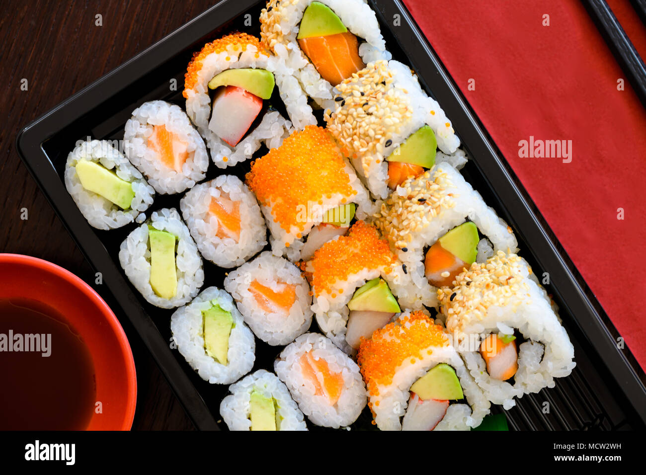 Sushi Take Away Box with Maki and Calofornia Rolls and Nigiri withSalmon and Tuna. Served in a takeaway Box with ginger and Wasabi. Sushi Set Stock Photo