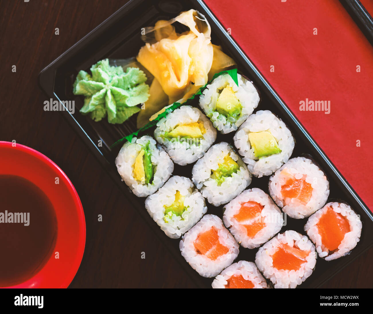 Sushi Take Away Box with Maki and Calofornia Rolls and Nigiri withSalmon and Tuna. Served in a takeaway Box with ginger and Wasabi. Sushi Set Stock Photo