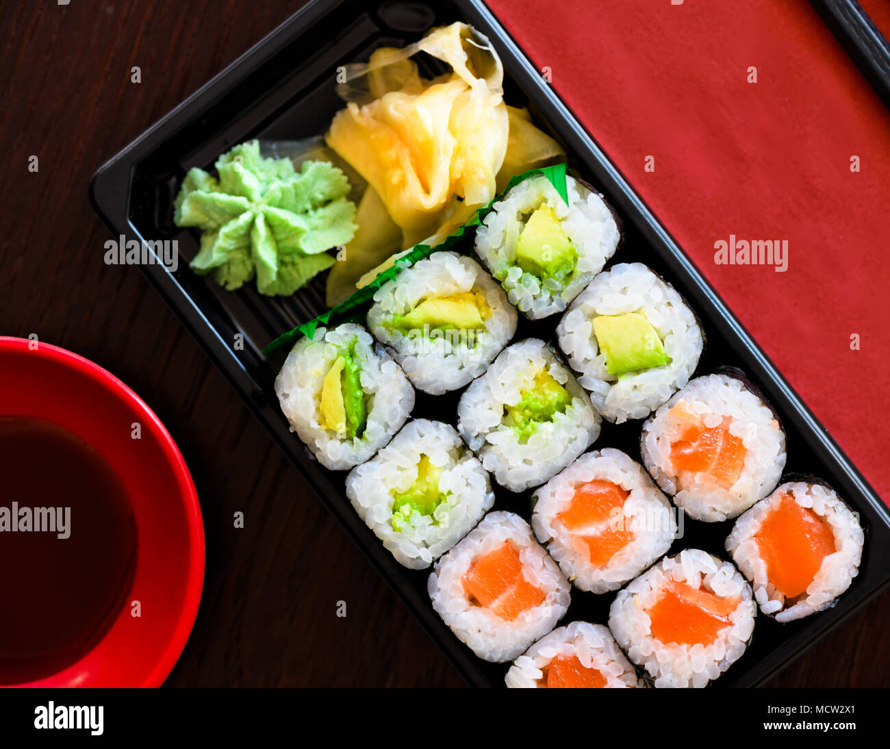 Sushi Take Away Box with Maki and Calofornia Rolls and Nigiri withSalmon and Tuna. Served in a takeaway Box with ginger and Wasabi. Sushi Set Stock Photo