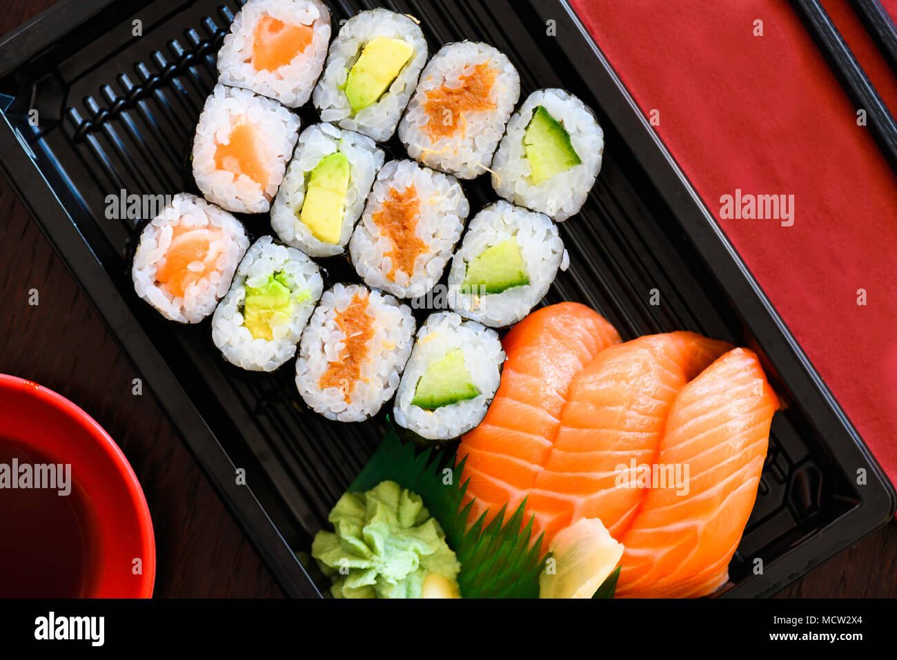 Sushi Take Away Box with Maki and Calofornia Rolls and Nigiri withSalmon and Tuna. Served in a takeaway Box with ginger and Wasabi. Sushi Set Stock Photo