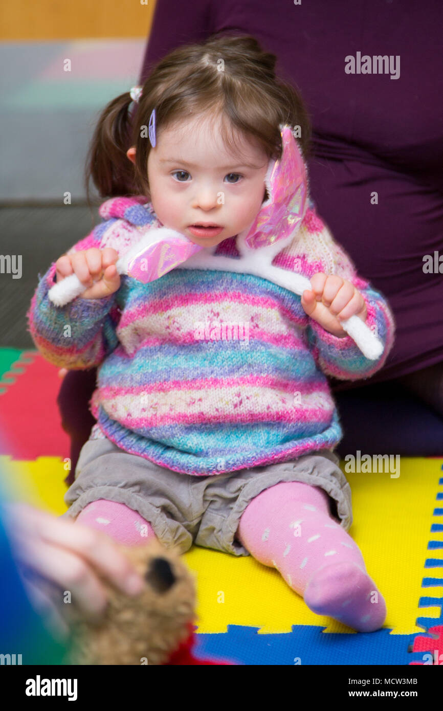 A young child with Downs Syndrome at playgroup, UK Stock Photo