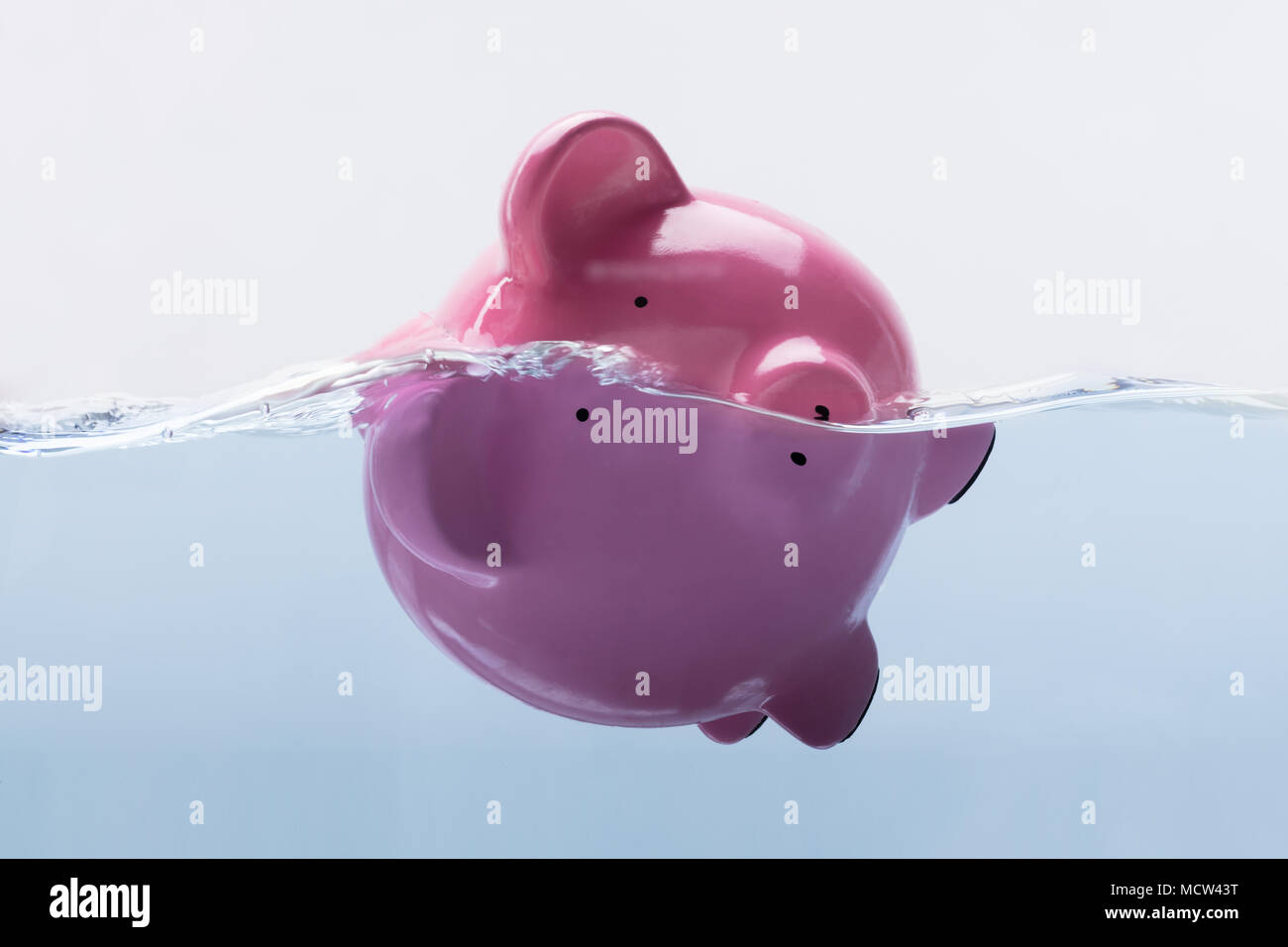 Close-up Of A Pink Piggy Bank Drowning In Water Stock Photo