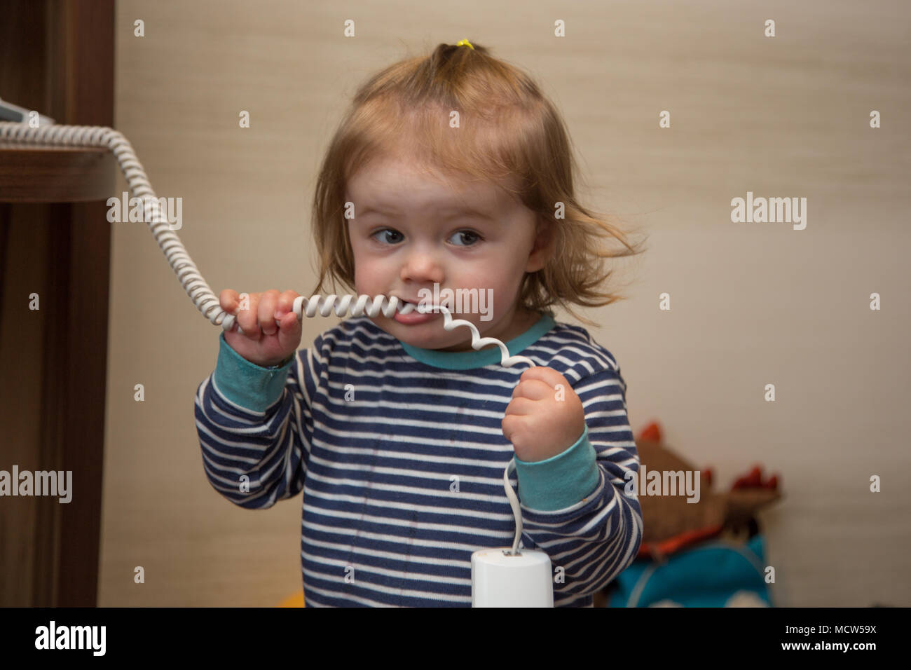 18 month old toddler girl playing with a house phone, UK Stock Photo