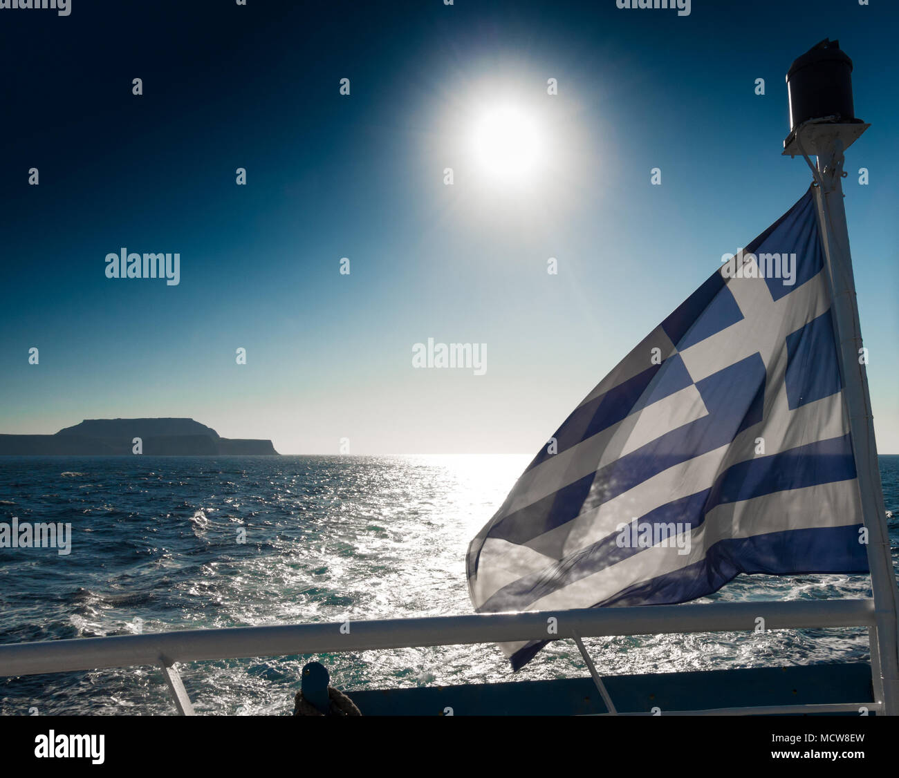 Scenic view of seascape and Greek flag on boat, Crete, Greece Stock Photo