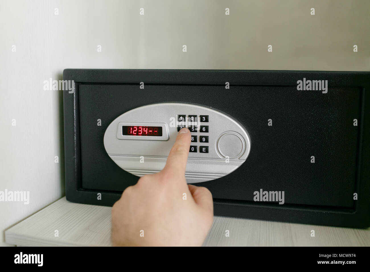 easy password. Hand press key on black safety box in hotel room