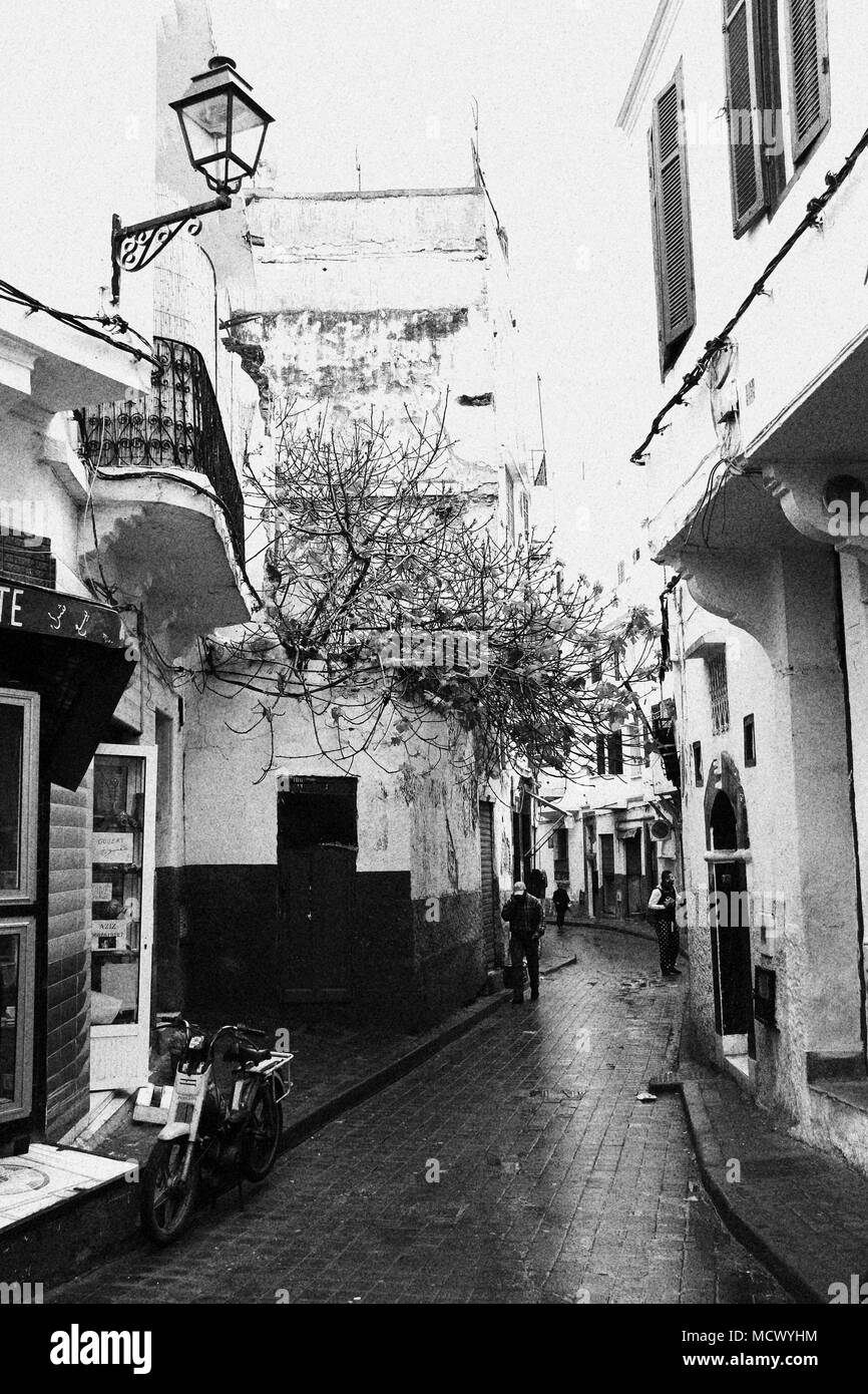 Old fashioned black and white picture of people walking through a narrow alley towards the old souk in Casablanca, Morocco Stock Photo