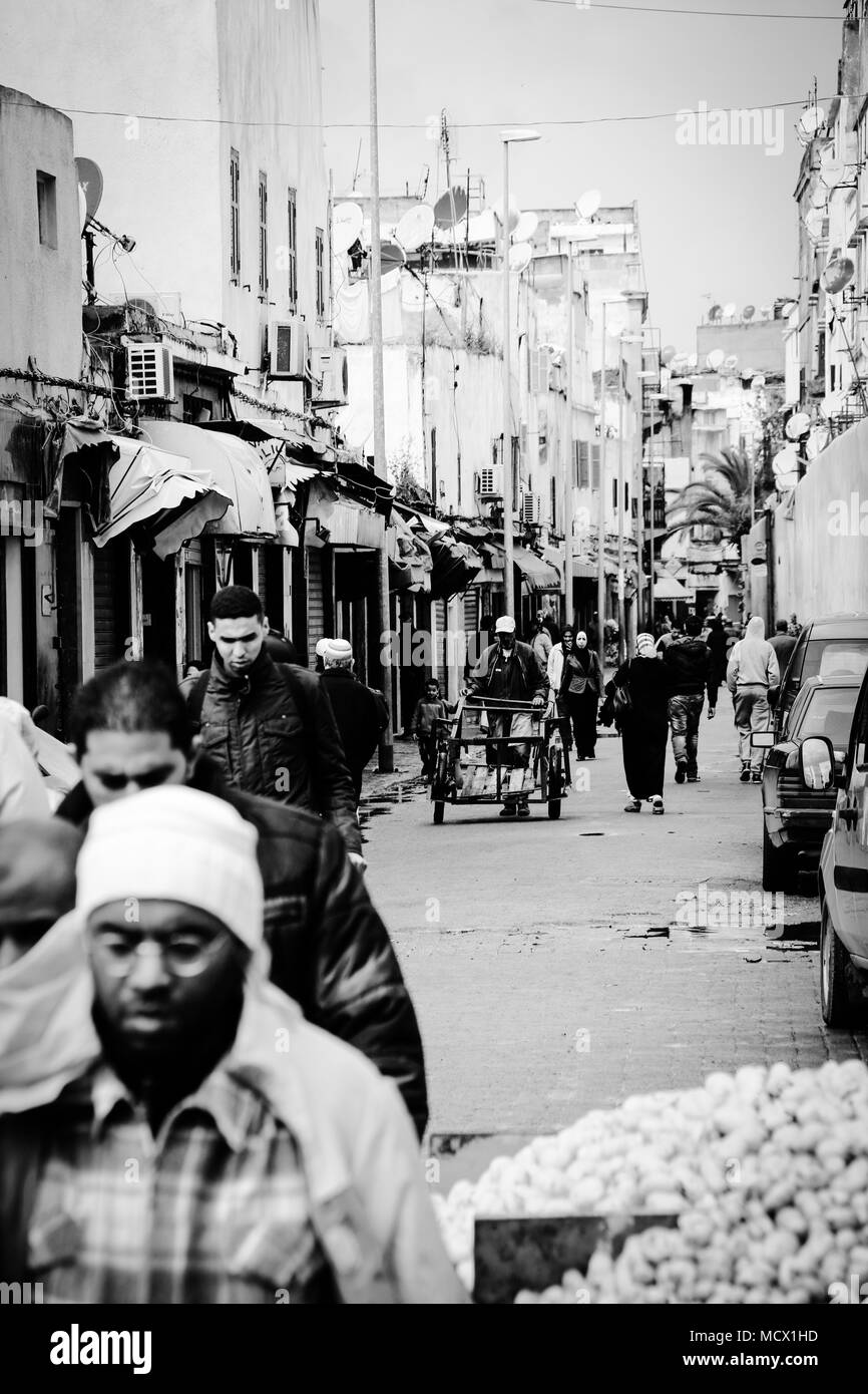 Old fashioned black and white picture of people walking through a narrow street towards the old souk in Casablanca, Morocco Stock Photo