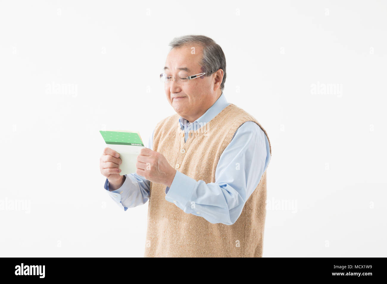 Senior man looking at passbook with smile Stock Photo