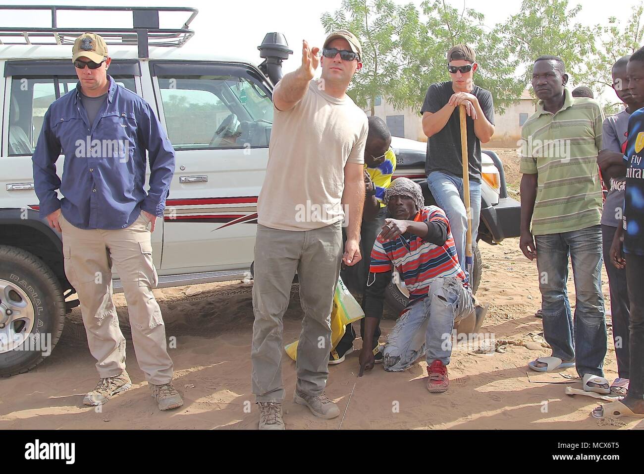 Service members of Task Force Darby teach Cameroonian community leaders the Do-Nou road construction method. Do-Nou is a low-cost, high labor method to create a sub-base for unimproved roads. 1st Lt. Donahue (middle) teaches participates to keep the section of road in a straight line. Other Army and Air Force service members, provide assistance with the hands-on training. TF Darby serve members are serving in a support role for the Cameroonian Military’s fight against the violent extremist organization Boko Haram. Stock Photo