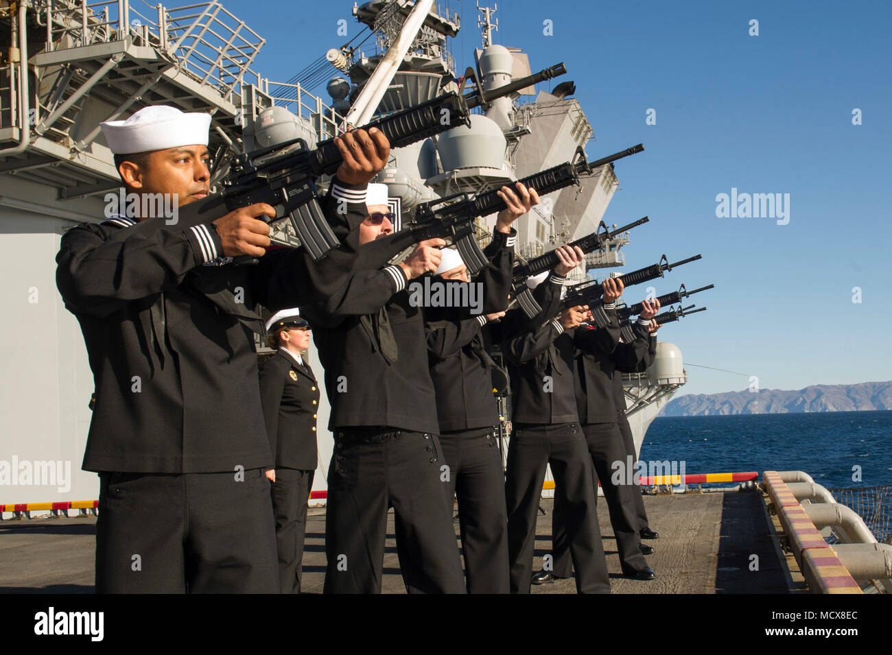 180304-N-ZS023-066  PACIFIC OCEAN (March 4, 2018) Sailors assigned to the amphibious assault ship USS America (LHA 6) perform a ceremonial gun salute during a burial-at-sea ceremony on the ship’s starboard elevator. America is underway off the coast of southern California preparing for an ammunitions offload prior to entering a planned maintenance availability period. (U.S. Navy photo by Mass Communication Specialist 3rd Class Vance Hand/Released) Stock Photo