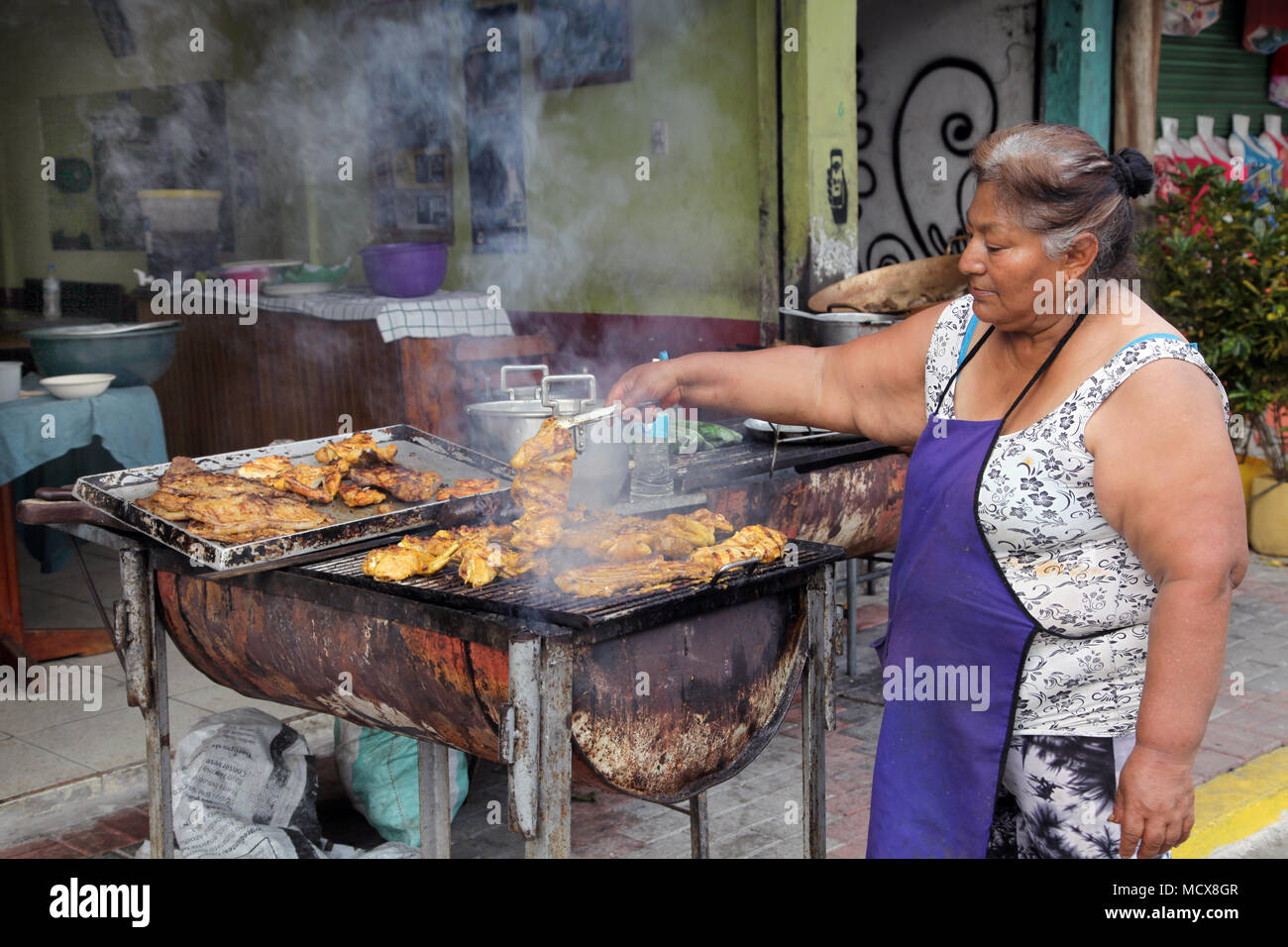 Woman roasting Chicken in Misahualli.Rio Napo.The Amazon region of Ecuador Stock Photo
