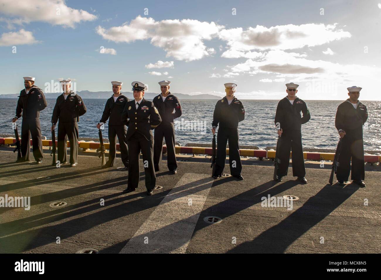 180304-N-ZS023-001 PACIFIC OCEAN (March 4, 2018) Sailors aboard the amphibious assault ship USS America (LHA 6), participate in a burial-at-sea ceremony on the ship’s starboard elevator. America is underway off the coast of southern California preparing for an ammunitions offload prior to entering a planned maintenance availability period. (U.S. Navy photo by Mass Communication Specialist 3rd Class Vance Hand/Released) Stock Photo