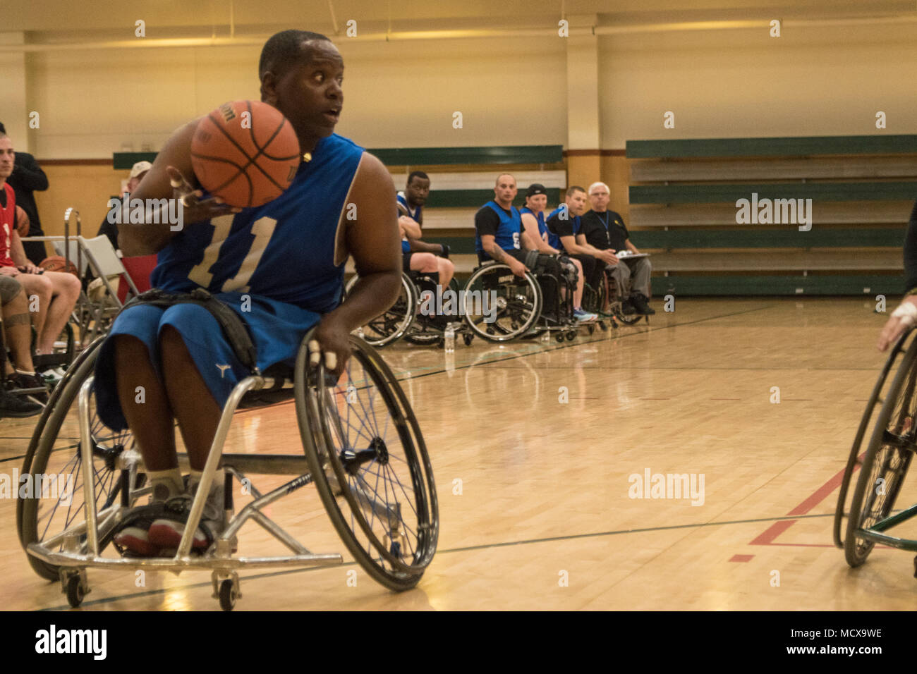 Retired U.S. Army Sgt 1st Class Carl Morgan, formerly assigned to the Warrior Transition Battalion, Fort Gillem looks for a teammate to pass the ball to during a game of Wheelchair Basketball at Fort Bliss, Texas, March 4, 2018. 74 wounded, ill or injured active duty Soldiers and veterans participate in a series of events that are held at Fort Bliss, Texas, Feb. 27 through March 9, 2018 as the Deputy Chief of Staff, Warrior Care and Transition host the 2018 Army Trials. (U.S. Army photo by Sgt. Brooks Schnetzler) Stock Photo
