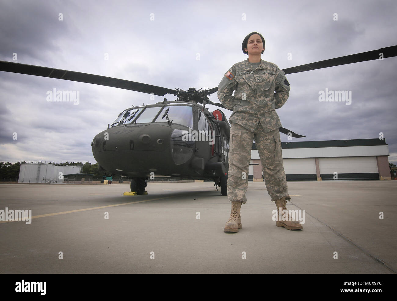 U.S. Army National Guard Cpl. Melinda Gulsever stands for a portrait with a UH-60L Black Hawk helicopter at the New Jersey National Guard's Army Aviation Support Facility, Joint Base McGuire-Dix-Lakehurst, N.J., March 5, 2018. Gulsever is an egine mechanic, and is also the head brewer for Backwards Flag Brewing Co. (U.S. Air National Guard photo by Master Sgt. Matt Hecht) Stock Photo