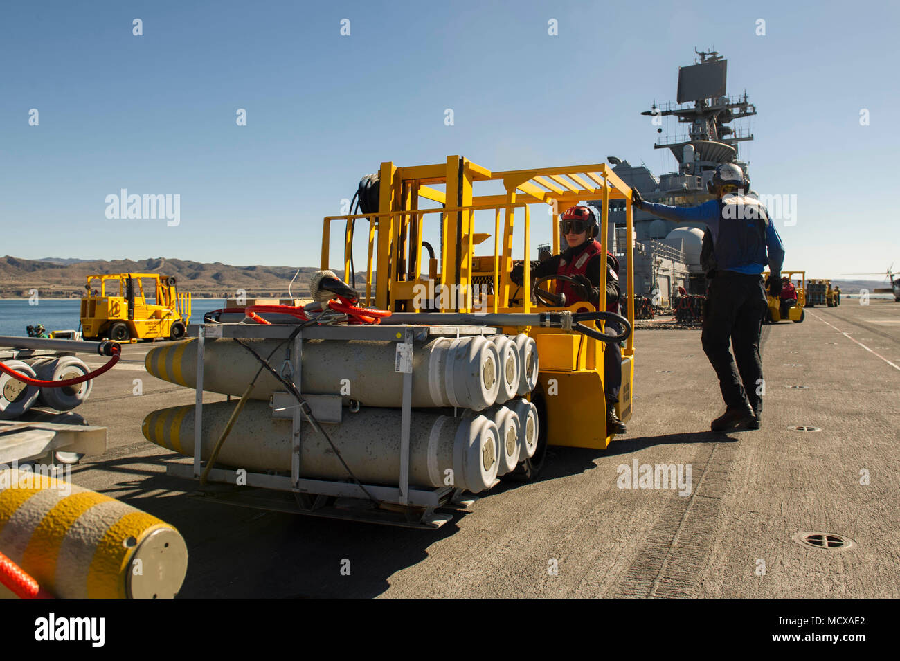 180305-N-ZS023-038  PACIFIC OCEAN (March 5, 2018) Aviation Ordnanceman Airman Tanner Priem, assigned to the amphibious assault ship USS America (LHA 6), moves ordnance using a forklift on the flight deck. America is underway off the coast of southern California conducting an ammunitions offload prior to entering a planned maintenance availability period. (U.S. Navy photo by Mass Communication Specialist 3rd Class Vance Hand/Released) Stock Photo