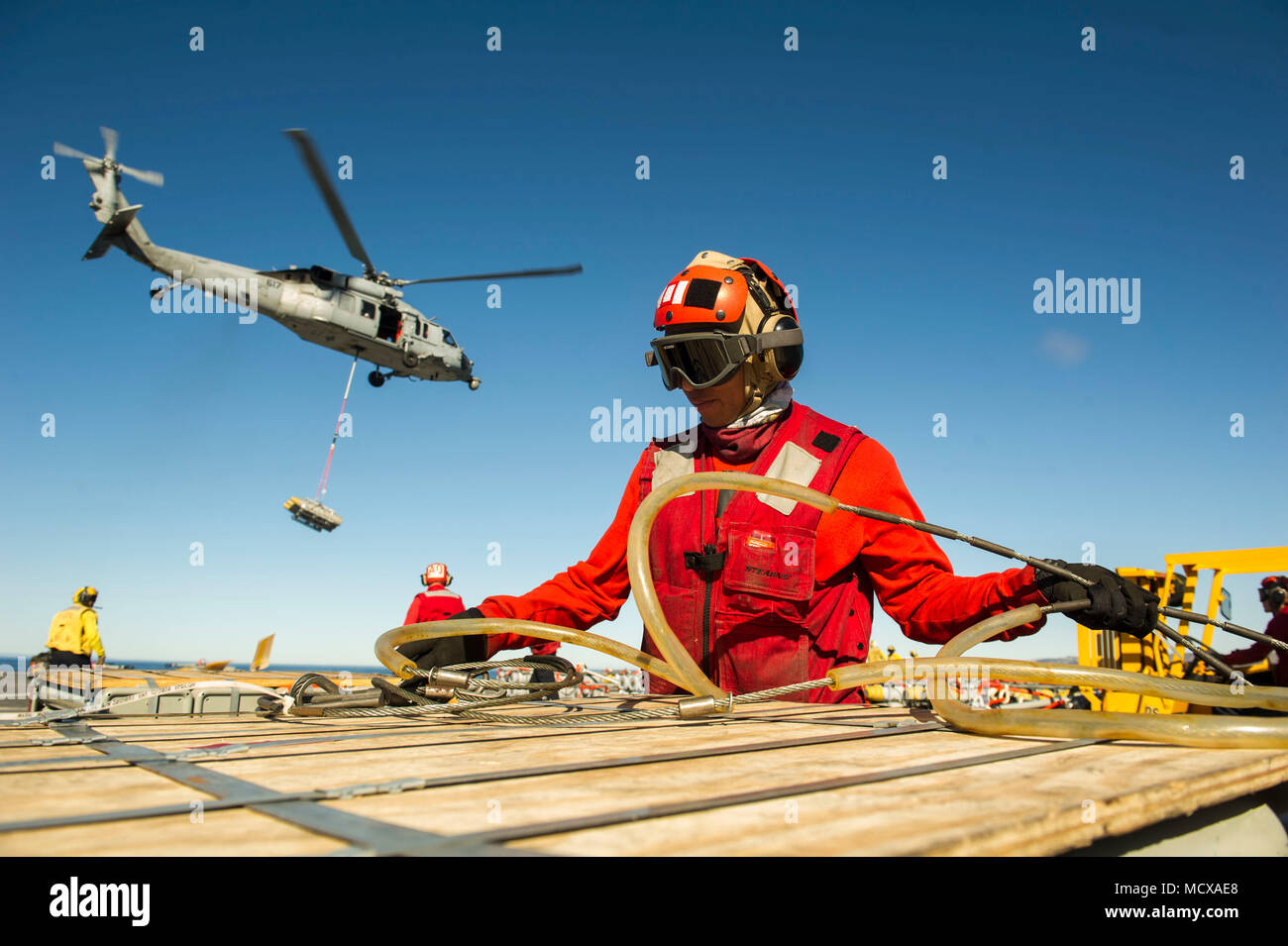 180305-N-ZS023-029  PACIFIC OCEAN (March 5, 2018) Aviation Ordnanceman Airman Sean Aldan, assigned to the amphibious assault ship USS America (LHA 6), attaches cargo cables to ordnance on the flight deck. America is underway off the coast of southern California conducting an ammunitions offload prior to entering a planned maintenance availability period. (U.S. Navy photo by Mass Communication Specialist 3rd Class Vance Hand/Released) Stock Photo