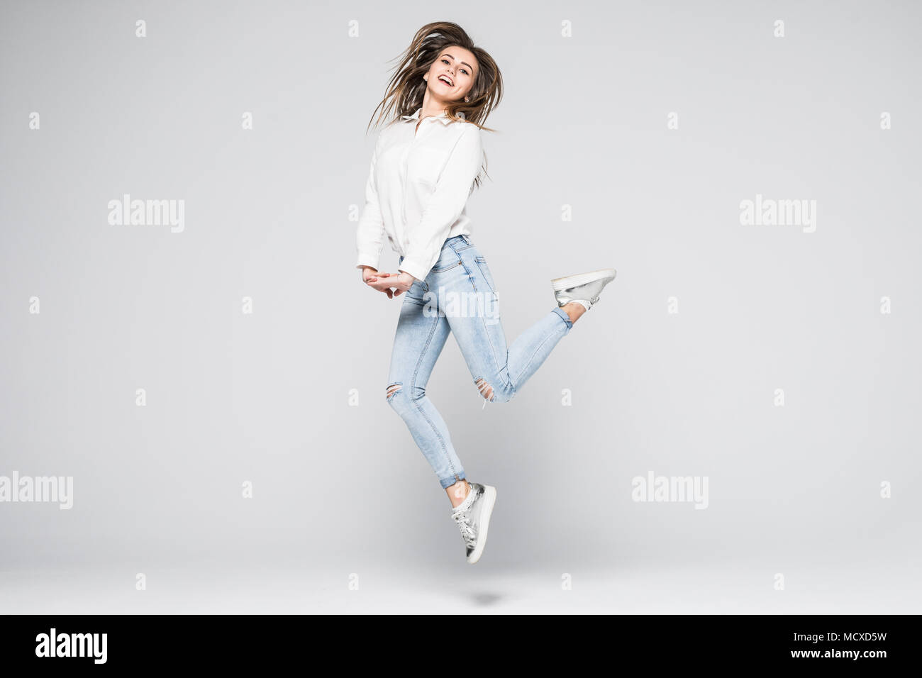 Full length portrait of a cheerful cute woman jumping isolated on a ...