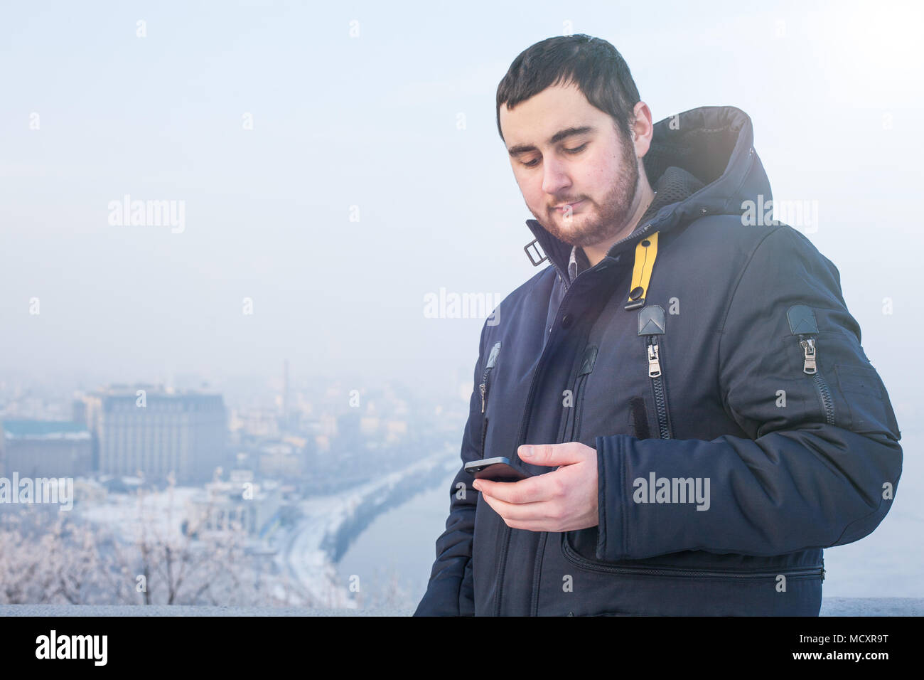 Man traveler using phone against winter cityscape Stock Photo