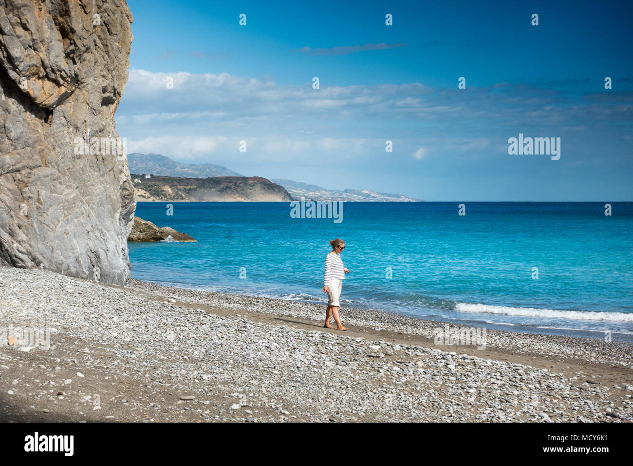 Young woman walking on beach, Crete, Greece Stock Photo