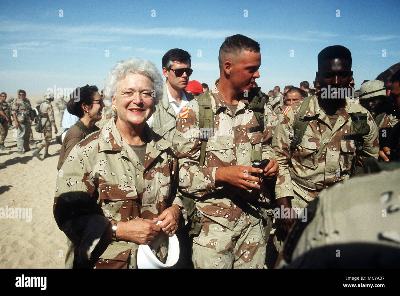 Members of the 197th Brigade, 24th Infantry Division escort Barbara Bush after she and President George Bush arrived in camp for a Thanksgiving Day visit during Operation Desert Shield. Stock Photo